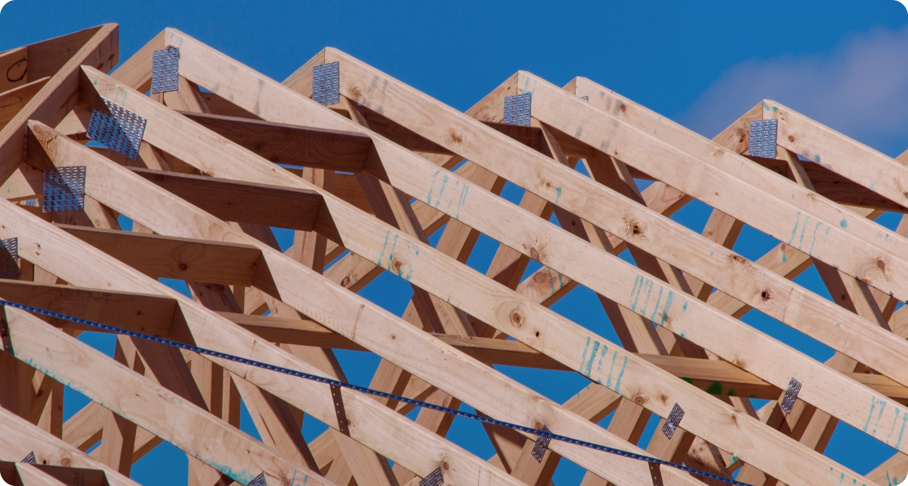 Roof truss in sunny weather conditions and blue sky.
